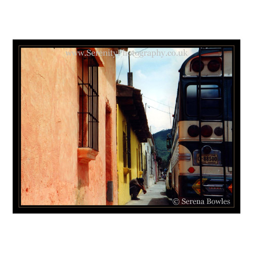 A bus driver takes a rest next on a doorstep. Antigua, Guatemala.